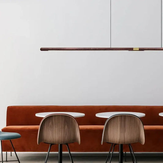 Luxury LED solid wood pendant light above modern dining area with stylish wooden chairs and orange velvet bench.