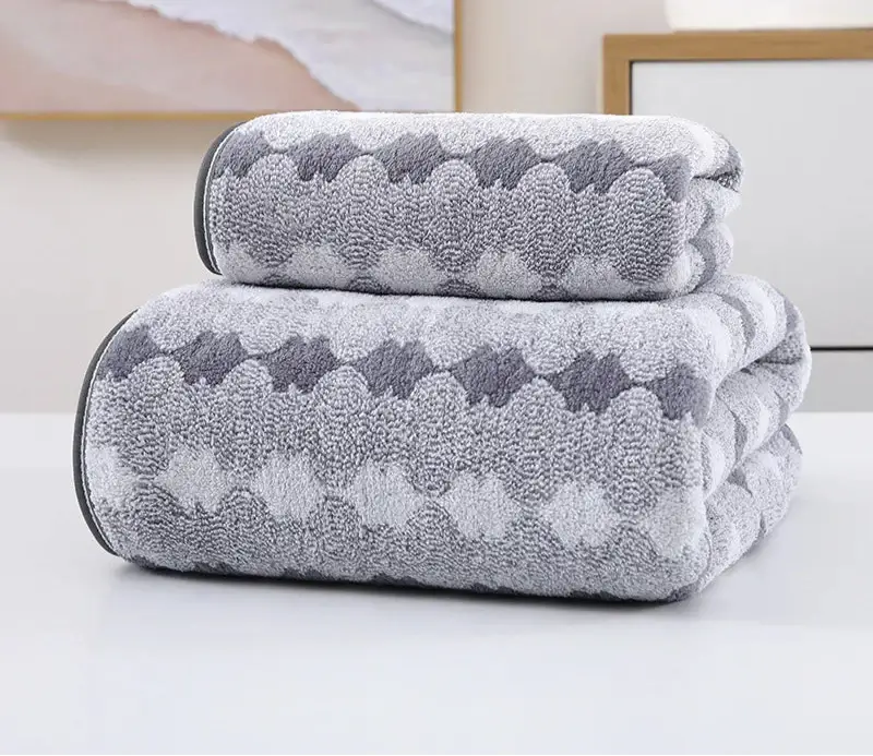Bamboo charcoal bath towel stacked on a table, showcasing luxury softness and absorbency for a spa-like experience.