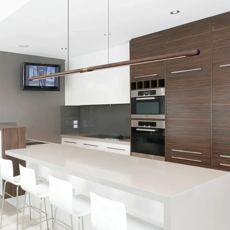 Luxury LED solid wood pendant light illuminating a modern kitchen with sleek cabinetry and marble countertop.