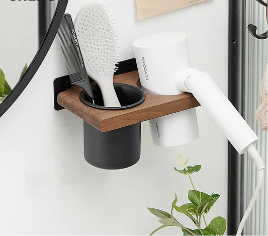 Wall-mounted hair care station with brush, comb, and hair dryer holder on a white wall.