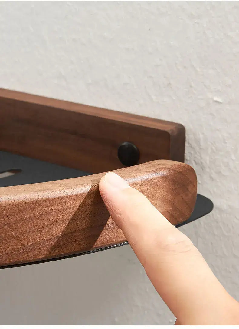 Close-up of finger touching Black and White Wall Mounted Bathroom Shelves featuring a wooden edge.