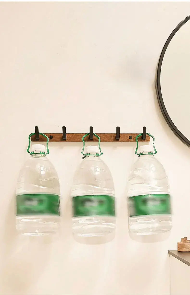Wood black hook holding three water bottles, perfect for space-saving storage in modern homes.