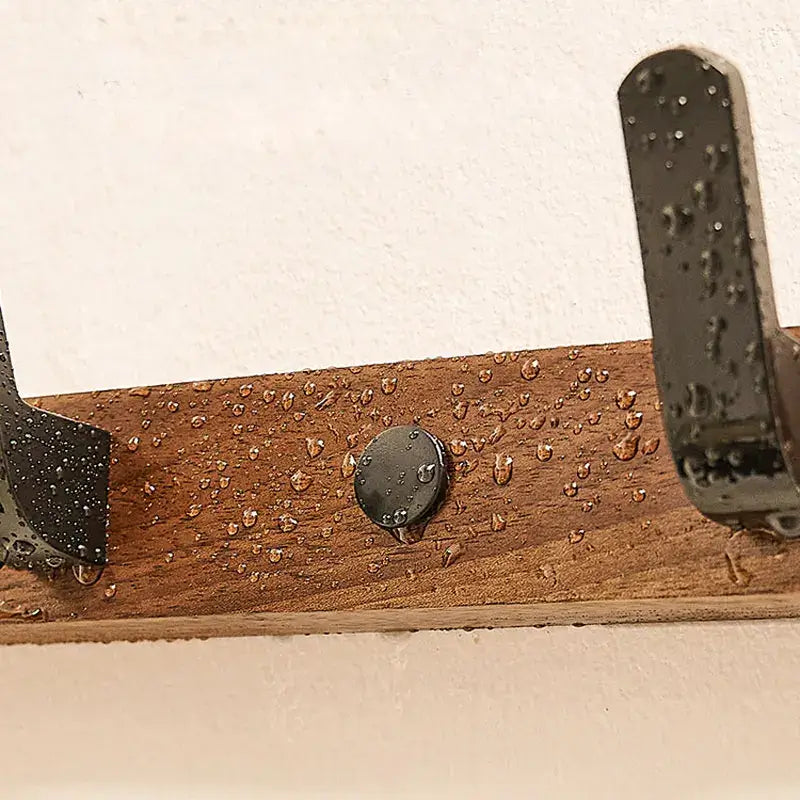 Close-up of the Wood Black Hook with water droplets, showcasing its durable design for bathroom or living room use.