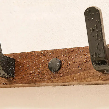 Close-up of the Wood Black Hook with water droplets, showcasing its durable design for bathroom or living room use.