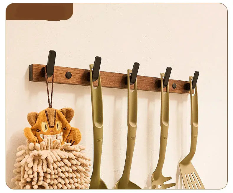 Wood black hook with kitchen utensils and a decorative plush toy, perfect for space-saving organization.