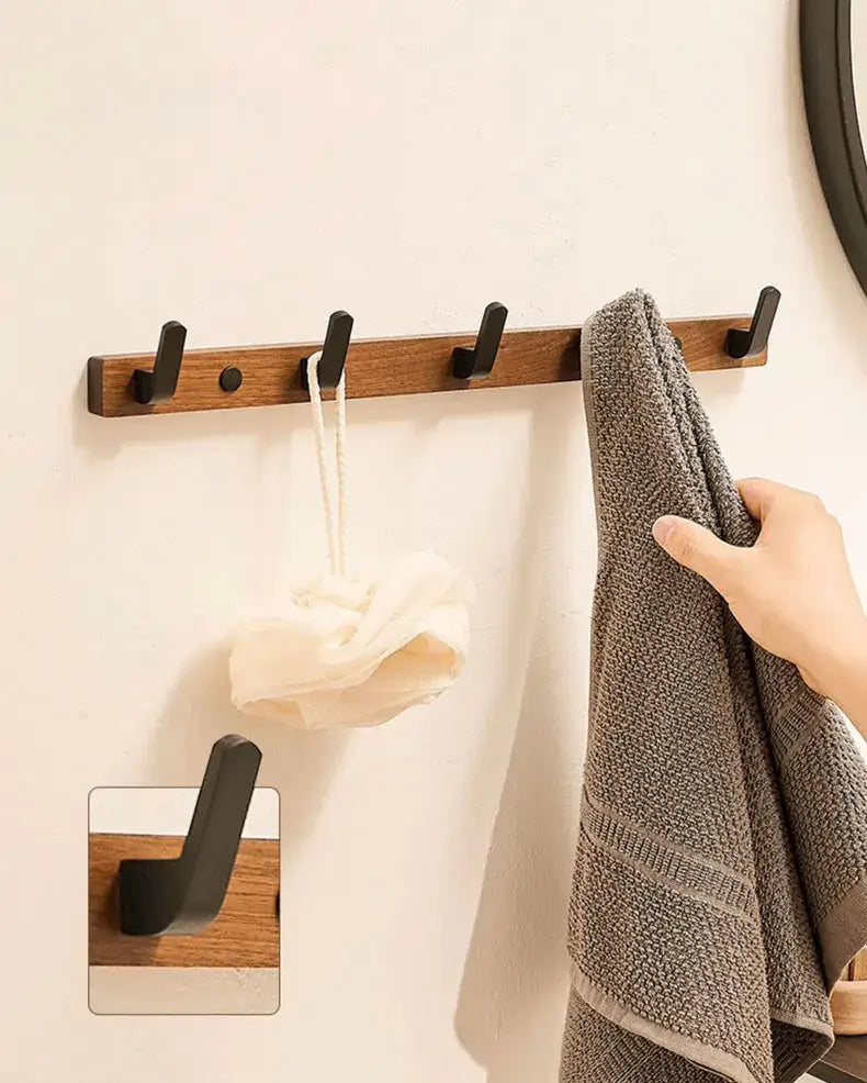 Wood black hook on wall holding towels and accessories, perfect for space-saving in bathrooms or living rooms by Housite.